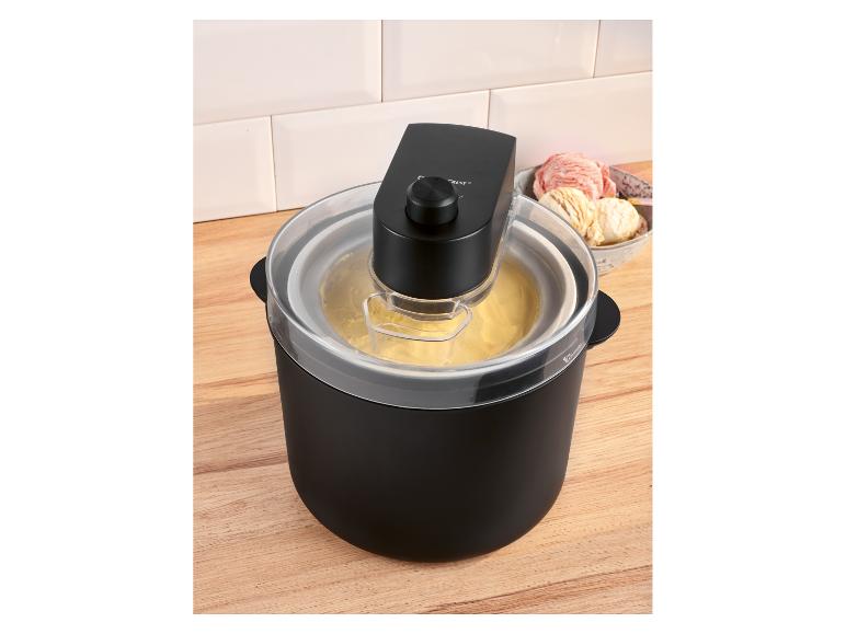 Schwarze Eismaschine mit gelbem Eis und einer Schüssel Eis im Hintergrund.