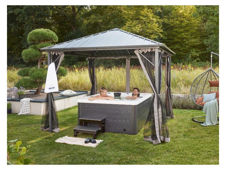 Paar entspannt in einem Outdoor-Whirlpool unter einem Pavillon mit Moskitonetzen.