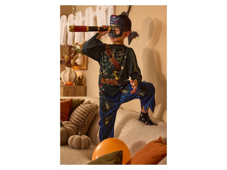 Kind im Halloween-Piratenkostüm blickt durch ein Spielzeugteleskop.