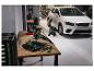 Autopoliermaschine und Hochdruckreiniger in Garage vor weißem Auto.