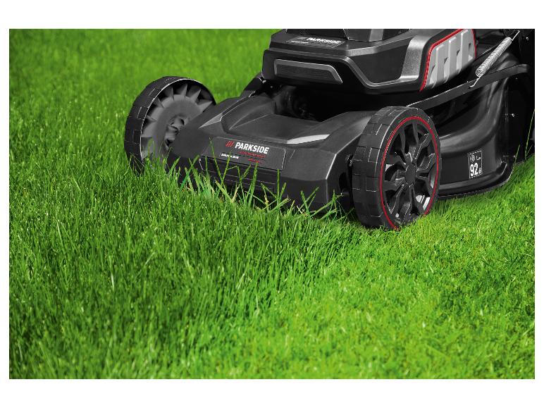 Schwarzer Parkside Performance Rasenmäher auf grünem Gras.