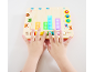 Kind spielt mit einem Musikspielzeug aus Holz mit bunten Lichtern.