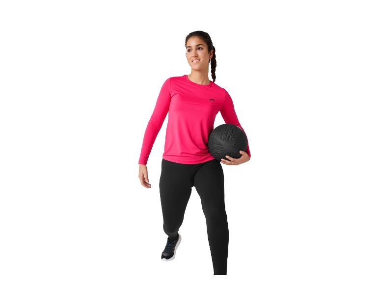 Frau in rosa und schwarzer Sportkleidung mit einem Medizinball.