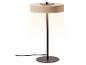 Moderne beige und schwarze Tischlampe mit warmem Licht, isoliert auf Weiß.