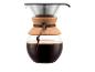 Glaskaffeekanne mit Korkband und Metallfilter, gefüllt mit Kaffee.