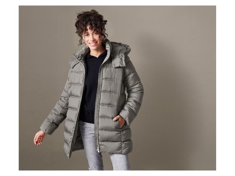 Frau in einer grauen Daunenjacke mit Kapuze.