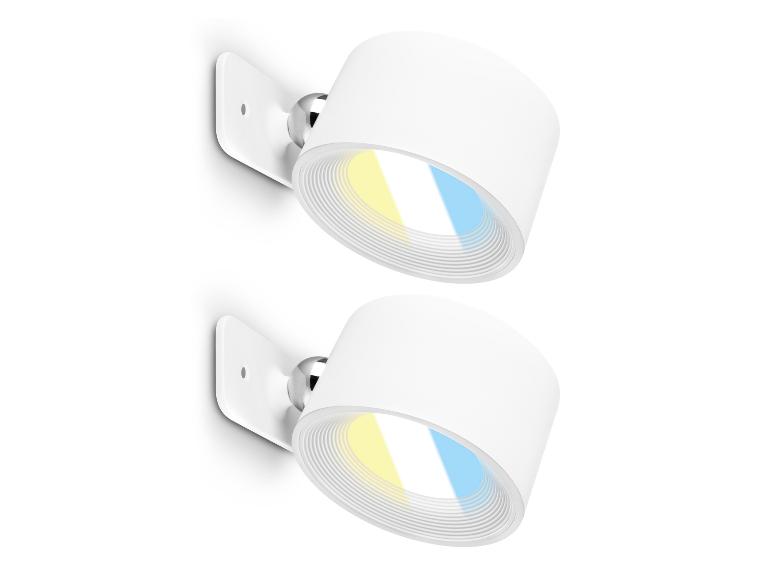 Zwei weiße Wandstrahler mit gelbem und blauem Licht, montiert auf einer weißen Oberfläche.