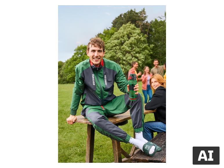 Mann im Trainingsanzug und grünen PARKSIDE Badepantoletten beim Picknick. [KI-generiertes Bild]