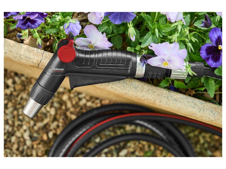 Schwarze und rote Parkside Performance Gießpistole mit Schlauch und Blumen.