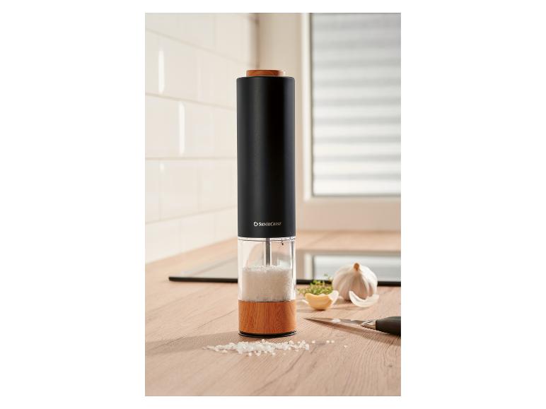 Schwarze Salzmühle mit Holzelementen auf einer Küchenarbeitsplatte.
