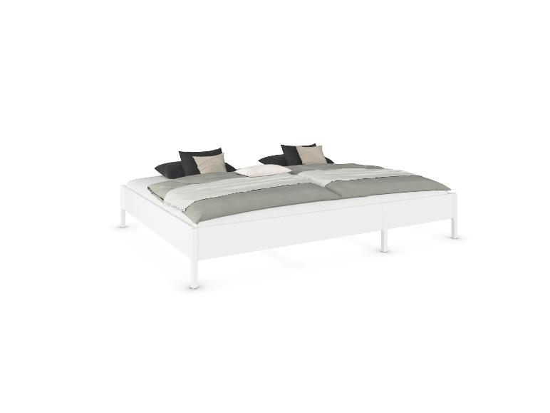 Weißes Doppelbett mit grauer Bettwäsche und schwarzen sowie beigen Kissen