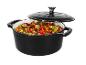 Ein schwarzer gusseiserner Topf mit leicht geöffnetem Deckel, gefüllt mit gedünstetem Gemüse.