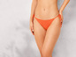 Eine Frau trägt einen orangenen Bikini-Slip.