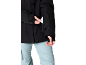 Schwarze Jacke mit Ärmeltasche, hellblaue Hose.