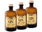 Drei bernsteinfarbene Gin-Flaschen mit Holzstopfen und Etiketten im Vintage-Stil.