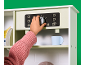 Kinderhand dreht Knopf an Spielzeug-Kaffeemaschine in Spielküche.