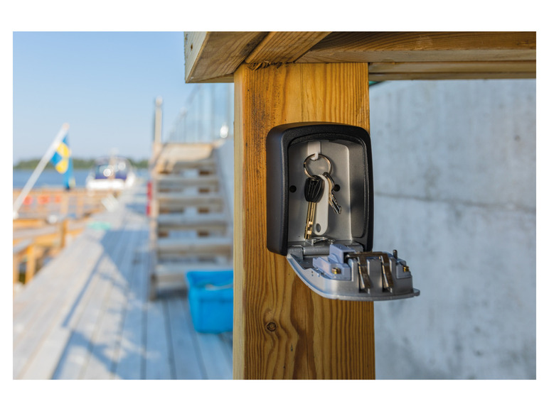 Ein Schlüsselsafe mit Schlüsseln, die an einem Holzpfosten befestigt sind.