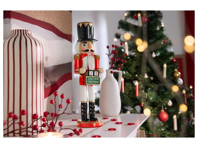 Nussknackerfigur mit einem Weihnachtscountdown-Schild auf einem Kaminsims.