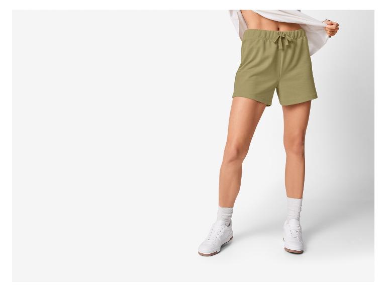 Damen-Sport Shorts in hellgrün und weiße Sneakers.