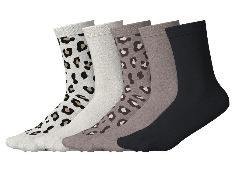 Fünf Paar Socken, darunter Leopardenmuster, einfarbig beige und schwarze Designs.