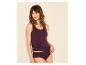 Frau in bordeauxfarbenem Tanktop und Slip, zur Seite blickend.