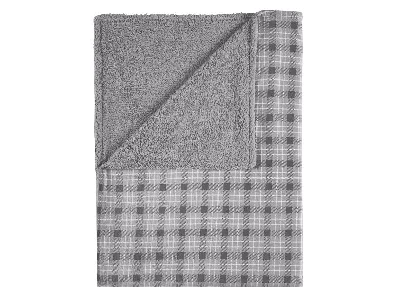 Weiche graue Decke mit Karomuster und flauschiger Seite.