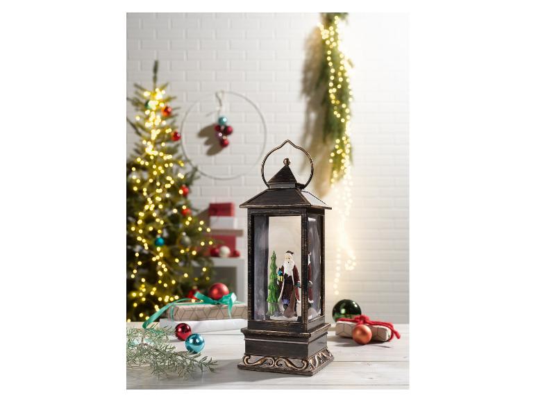 Weihnachtslaterne mit Weihnachtsmann und Weihnachtsbaum im Hintergrund