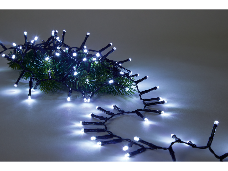 Kaltweiße LED-Weihnachtsbeleuchtung auf einem grünen Tannenzweig.