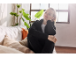 Frau in schwarzer Loungewear entspannt auf einem Sofa mit Kissen, im Sonnenlicht.