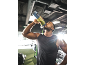 Mann trinkt grünen Smoothie aus tragbarem Mixer im Fitnessstudio.