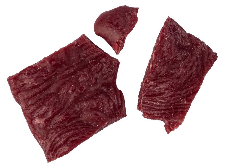 Stücke von Trockenfleisch auf weißem Hintergrund.