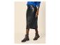Frau in blauem Pullover, schwarzem Lederrock und schwarzen Stiefeletten.
