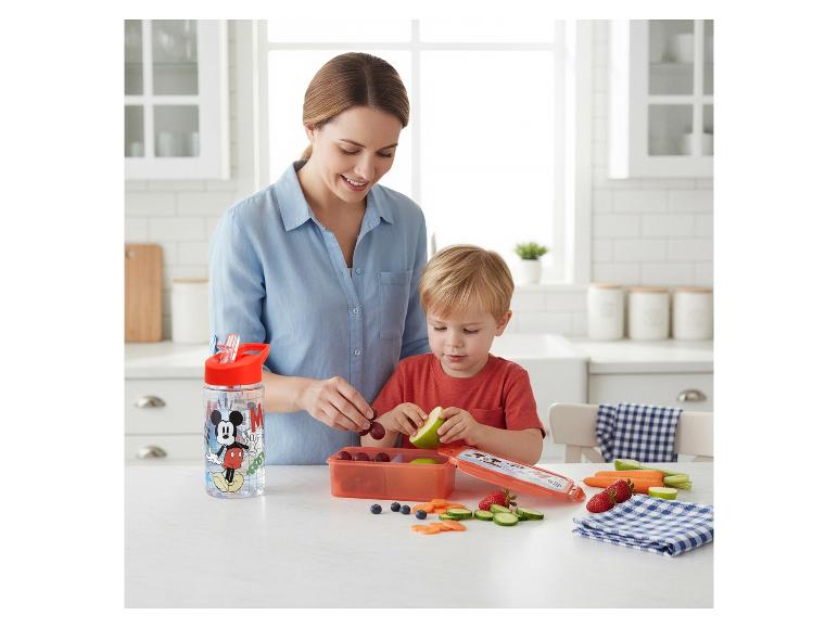 Mutter und Kind bereiten einen gesunden Snack mit Trinkflasche und Brotdose zu.