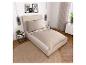Modernes Schlafzimmer mit beigem Bett, rundem Teppich, Nachttischen und weißer Kommode.