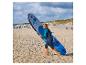 Ein Mädchen in Neoprenanzug trägt ein Fanatic Air 8'8' SUP-Board am Strand.