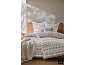 Gemütliche Bettwäsche im Winter-Design mit einer Strickdecke auf einem Holzbett