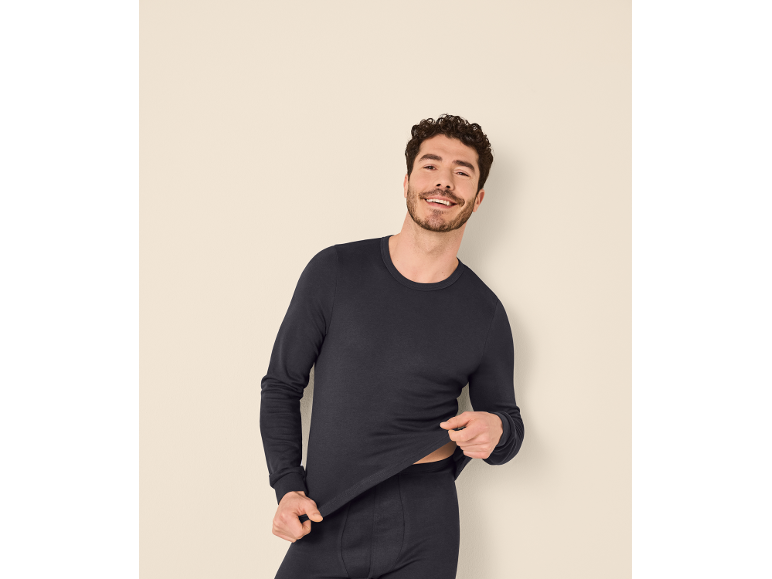 Mann in dunkelblauem Langarmshirt und Unterwäsche.