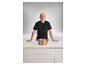 Andre Agassi steht hinter einer Theke mit einem Silvercrest Kupfertopf.