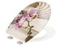 Toilettensitz mit lila Orchideenmotiv und Zen-Sandhintergrund.