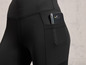 Schwarze Leggings mit einem Handy in der Gesäßtasche