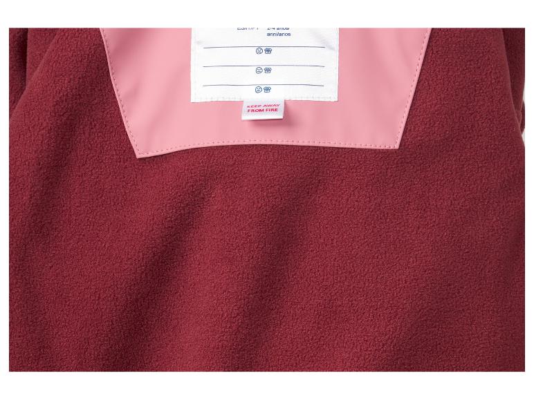 Nahaufnahme eines roten Fleece-Kleidungsstücks mit rosa Innenfutter und einem 'Von Feuer fernhalten'-Etikett.