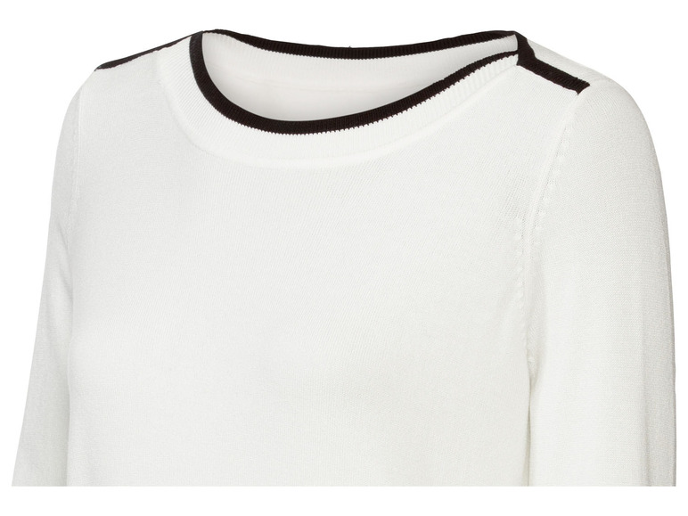 Weißer Pullover mit schwarzem Besatz an Hals und Schultern.