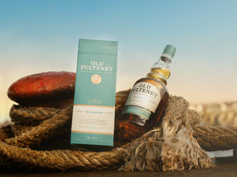 Flasche und Karton Single Malt Whisky mit maritimem Thema, auf dicken Seilen.