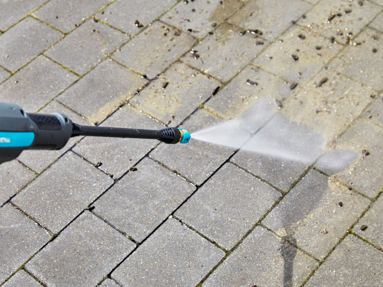 Ein Hochdruckreiniger reinigt eine Betonterrasse.