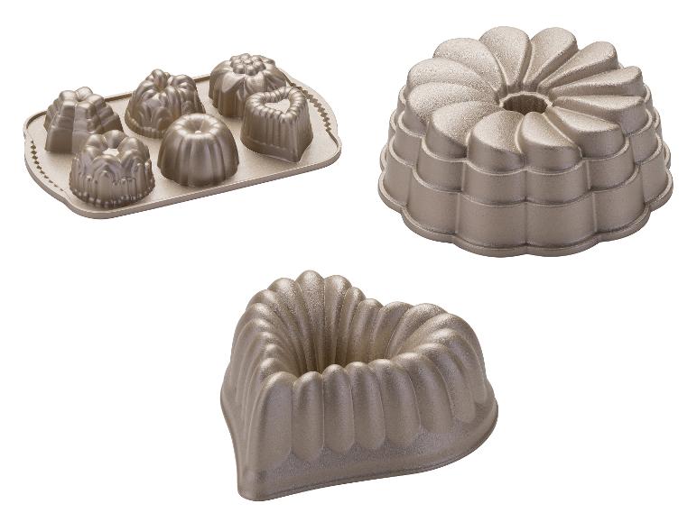 Metallbackformen in verschiedenen Formen, darunter eine Herzform und eine Gugelhupfform.