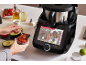 Smarte Küchenmaschine zeigt Rezept, mit einer Person, die Salsa zubereitet.