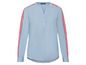 Hellblaue Bluse mit roten Streifen an den Ärmeln.