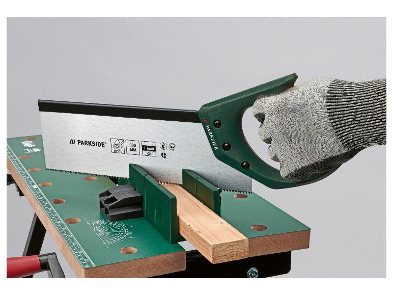 Handsäge schneidet Holz auf einer Werkbank, mit Schutzhandschuh.