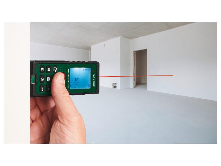 Hand hält ein PARKSIDE Laser-Entfernungsmessgerät, das 16.75m in einem leeren Raum anzeigt.