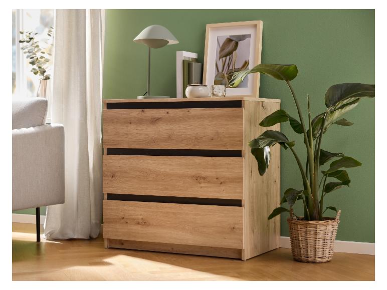 Holzkommode mit drei Schubladen, daneben ein Sofa, Vorhänge und Pflanzen.